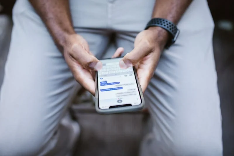 Man holding a phone waiting for a message that suggest a stalled conversation